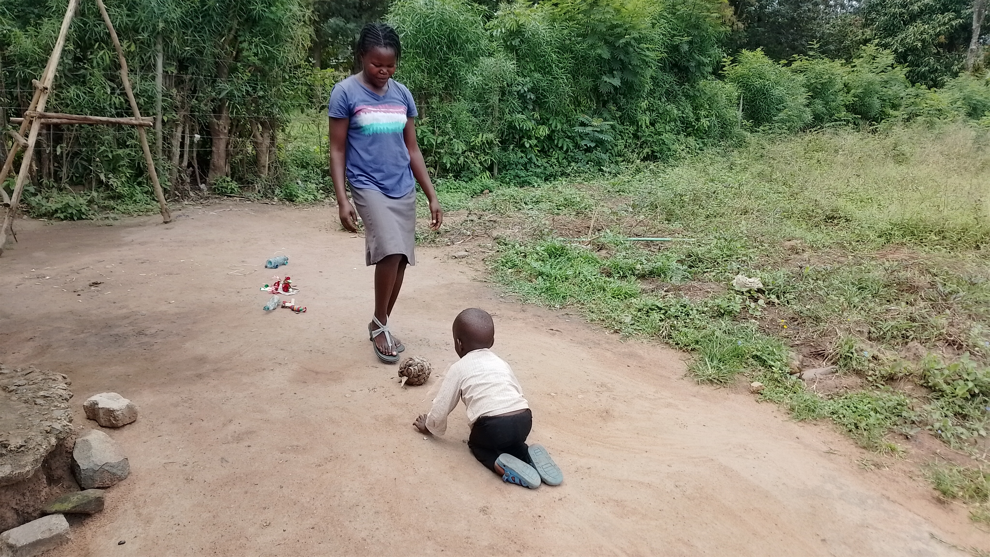 Elizabeth, a confident mother, happily playing with her son Samuel in Kisumu, reflecting their improved bond.